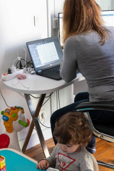 Imagen ilustrativa. Mujer junto a su hijo en una sesión de teletrabajo.