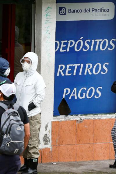 Personas hacen fila en los exteriores de un corresponsal no bancario en Quito, en 2020. 