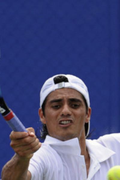 El ecuatoriano Nicolás Lapentti devuelve el balón al francés Paul-Henri Mathieu durante el partido de tenis de primera ronda de individuales masculinos en los Juegos Olímpicos de Pekín 2008, el 11 de agosto.
