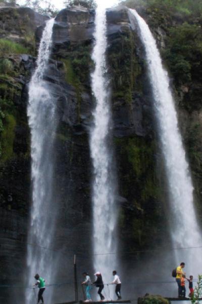 Personas caminan por un puente colgante frente a una de las cascadas del complejo el Molinuco, el 4 de junio de 2014.