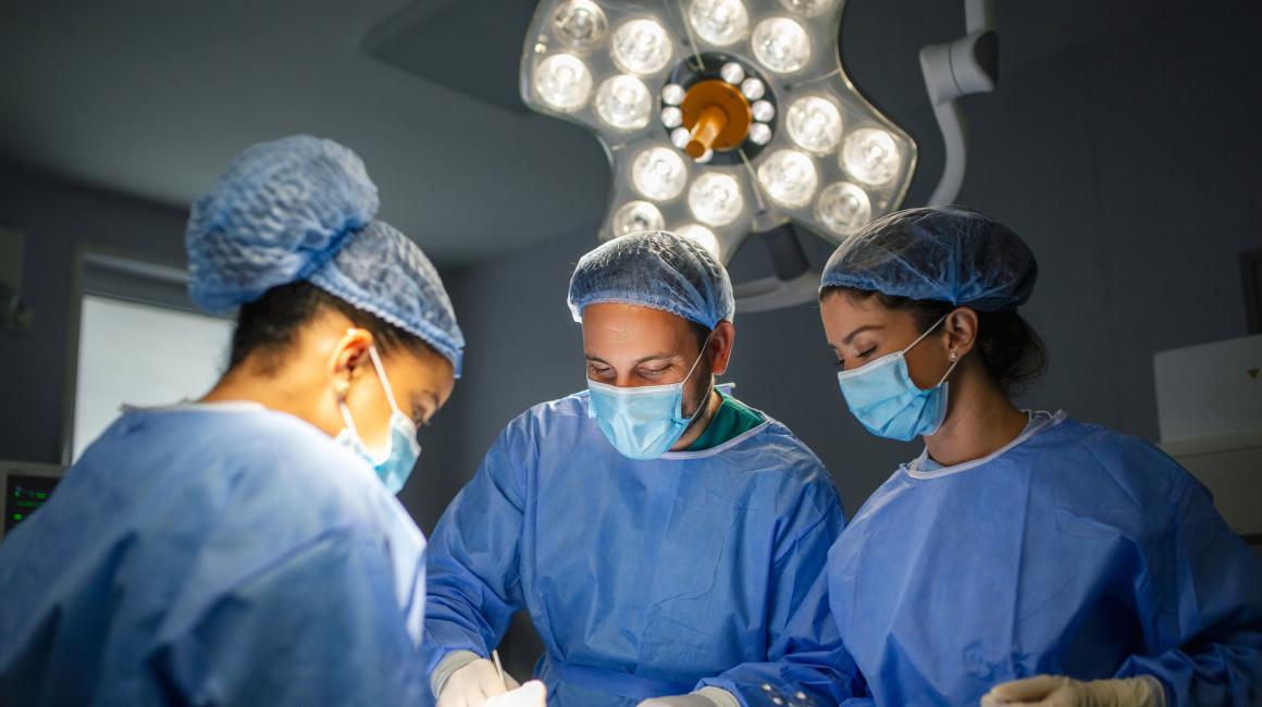Equipo de cirujanos en procedimiento médico.