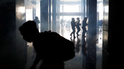 Militares y manifestantes corren en el interior de la Asamblea Nacional.