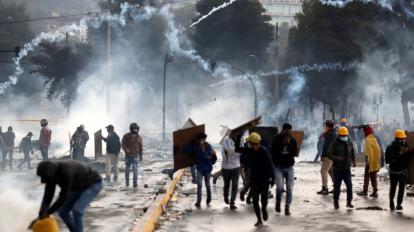 Manifestantes corren entre los gases lacrimógenos lanzados por la policía en una nueva jornada de choques el domingo 13 de octubre de 2019, en Quito.