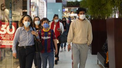 Personas caminan en un centro comercial en el centro norte de Quito, en diciembre de 2021. 