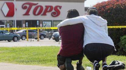 Dos personas lamentan la muerte de sus familiares en el supermercado Tops, de Estados Unidos, el 15 de mayo de 2022.