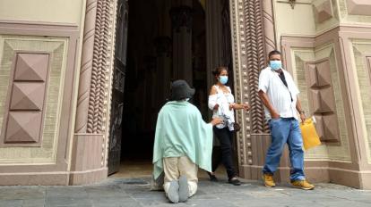 Una mujer pide dinero en una iglesia en Guayaquil, el 13 de septiembre de 2022.