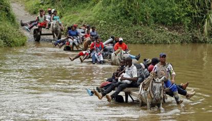 Migrantes cruzan por el Tapón del Darién en 2023.