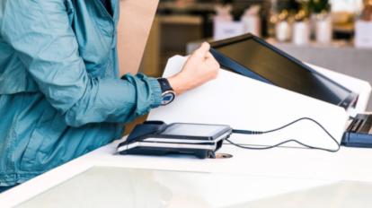 Una mujer paga en un local comercial con un reloj inteligente en 2020.