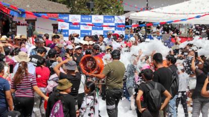 Turistas juegan con espuma durante el Carnaval de Guaranda, en 2023.