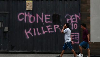 Dos jóvenes caminan junto a graffitis con el nombre de la banda criminal de los Chone Killers y su líder máximo, alias 'Ben 10', en el cantón Durán, provincia de Guayas, el 8 de octubre de 2023.