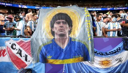 Hinchas de la selección argentina alzan una bandera con el rostro de Diego Maradona en el partido frente a la selección de Suiza por el Mundial, el 11 de julio de 2026.