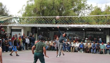 Personas jugando ecuavóley en La Carolina mientras una multitud los observa.