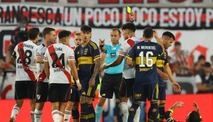 El árbitro argentino Darío Herrera muestra una tarjeta amarilla al defensa, Marcos Acuña, durante el partido entre River Plate y Boca Juniors, en el estadio MAS Monumental, el 19 de abril de 2026.