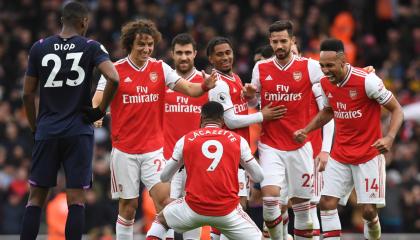 Los jugadores del Arsenal festejan un gol en grupo, en un partido por la Premier League.