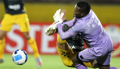 El arquero Darwin Cuero, de Universidad Católica, choca con Martín Prost, de The Strongest, en un partido jugado en Quito, el 10 de marzo de 2022.