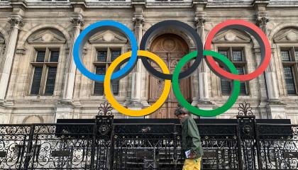 Un hombre pasa frente a los Anillos Olímpicos en el Hotel De Ville de París, el 2 de septiembre de 2022.