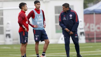 Nicolás Córdova conversa con dos futbolistas en un entrenamiento, en Santiago, el 17 de noviembre de 2023.