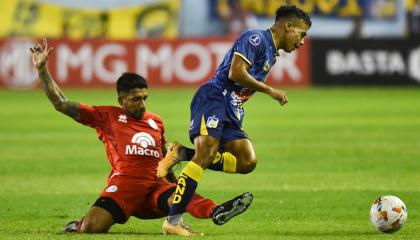 Maikel Reyes AlcÍvar (d) de Delfín disputa el balón con Ariel GarcÍa de Belgrano este 11 de abril de 2024, en un partido de la fase de grupos de la Copa Sudamericana.