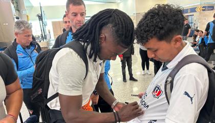 El jugador de Liga de Quito, Ricardo Adé, le firma la camiseta a un hincha de la 'U' en el Aeropuerto Mariscal Sucre, el 22 de abril de 2024.