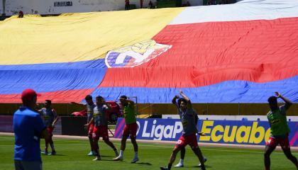 Los jugadores de El Nacional entrenan con la bandera del club de fondo, el 12 de mayo 2024.