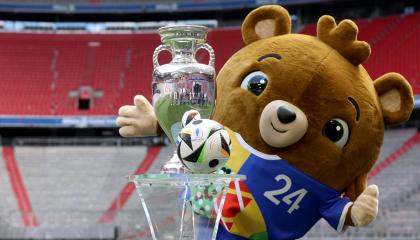 La fotografía tomada el 13 de mayo de 2024 muestra a Albaert, mascota del Campeonato Europeo de Fútbol UEFA Euro 2024, posando junto al trofeo del torneo y un balón en el estadio Allianz Arena.