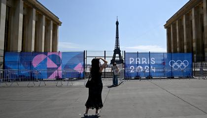 Una mujer posa en el Trocadero frente a la Torre Eiffel parcialmente oculta por una valla, antes de los Juegos Olímpicos de París 2024, el 19 de julio de 2024.