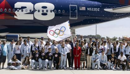 La alcaldesa de Los Ángeles sostiene la bandera olímpica junto a decenas deportistas estadounidenses, el martes 13 de agosto de 2024.