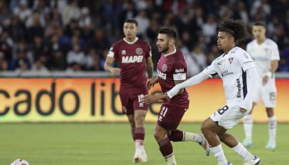 Marco Angulo, de Liga, disputa un balón con Eduardo Salvio, de Lanús, el miércoles 14 de agosto en el estadio Rodrigo Paz Delgado, por la Copa Sudamericana.