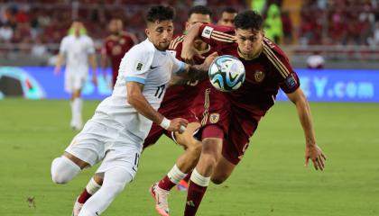 Nahuel Ferraresi de Venezuela disputa un balón con Cristian Olivera Ibarra de Uruguay, el martes 10 de septiembre, por la Fecha 8 de Eliminatorias, en el estadio Monumental de Maturín.