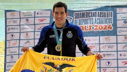 El nadador ecuatoriano, Esteban Enderica, posa con la bandera de Ecuador luego de ganar los 5 kilómetros en el Sudamericano de Aguas Abiertas, el domingo 6 de octubre de 2024.