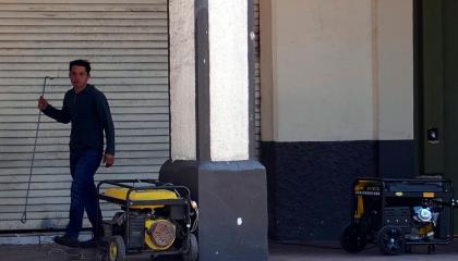 Ciudadano camina junto a generadores eléctricos, artefactos necesarios para los apagones en Ecuador.