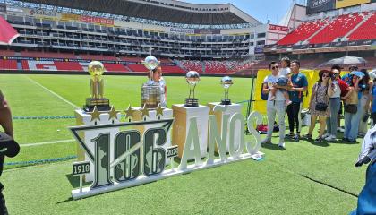 Hinchas de Liga de Quito se toman fotos con las copas internacionales del club, el 19 de octubre de 2024.