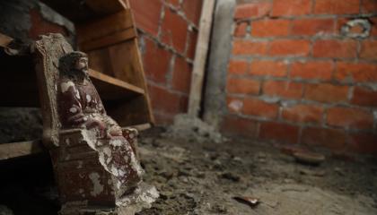 Figura de un Cristo hallada junto a sangre seca, una vasija de barro y diversos materiales en el suelo de una vivienda vacía, allanada por el Bloque de Seguridad en Fincas Delia, al sureste de Durán, el 23 de julio de 2024.