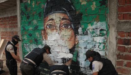 Policías borran un mural alusivo a bandas criminales en el Suburbio de Guayaquil, en el distrito Portete, afectado por enfrentamientos entre los grupos Los Duendes y Freddy Kruger's.