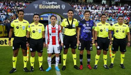 Los capitanes de Liga de Quito, Ezequiel Piovi, y de Independiente del Valle, Richard Schunke, junto a los árbitros de la final de ida de la LigaPro, el sábado 7 de diciembre de 2024.