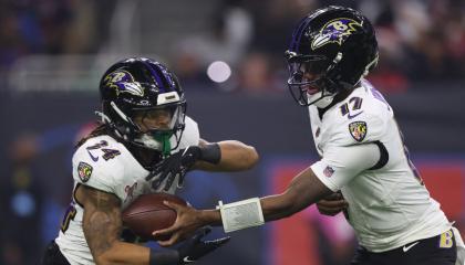 Josh Johnson de los Baltimore Ravens le entrega el balón a Keaton Mitchell durante el último cuarto ante Houston Texans en el NRG Stadium, el 25 de diciembre de 2024.