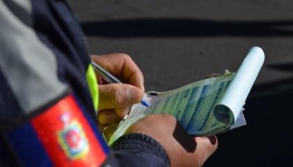 Imagen referencial de un agente de tránsito de la AMT con una citación.