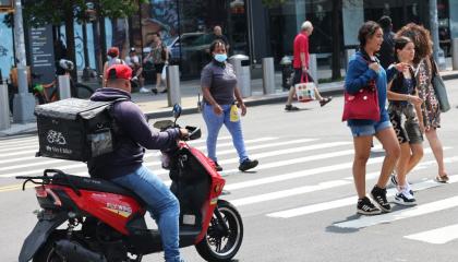 Un trabajador de entrega a domicilio se moviliza en Flatbush Avenue, en la zona de Brooklyn, Nueva York. Las aplicaciones han incrementado controles biométricos, una realidad que impacta a migrantes sin documentos.