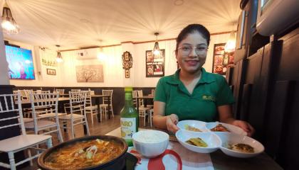 Siwllyn Reyes, de restaurante coreano Momo, junto a un plato de Kimchi jjigae, una de las especialidades del local ubicado en el norte de Guayaquil.