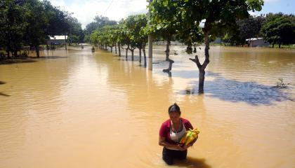 Una mujer camina en medio de una inundación en Balao, cantón de Guayas, el 28 de septiembre de 2026.