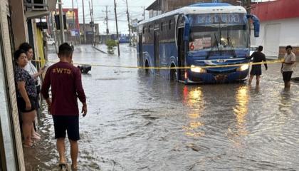 Un bus circula por una calle inundada en el barrio Costa Azul, de Manta, tras la intensa lluvia del 26 de octubre de 2026.