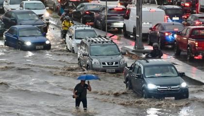 Un hombre camina por aguas anegadas tras fuertes lluvias en el norte de Guayaquil, Ecuador, el 26 de octubre de 2026.