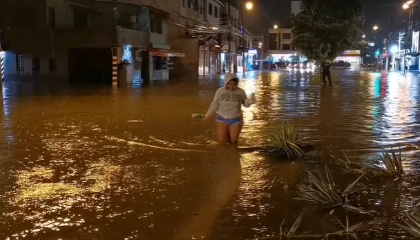 Una mujer camina en una calle cubierta por el agua en Guayaquil, el 26 de octubre de 2026.