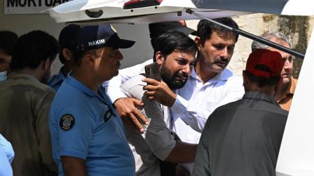 Un hombre llora frente al ataúd de su hijo muerto en un incendio en el Instituto de Ciencias Médicas de Pakistán, en Islamabad, el 26 de agosto de 2026.