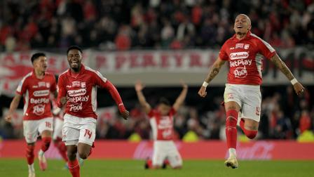 Santa Fe's Uruguayan forward #09 Franco Fagundez (C) and forward #14 Luis Palacios celebrate after winning the penalty shootout of the second leg of the Copa Sudamericana round of 16 football match between Argentina's River Plate and Colombia's Independiente Santa Fe at Mas Monumental stadium in Buenos Aires on August 26, 2026. (Photo by JUAN MABROMATA / AFP)