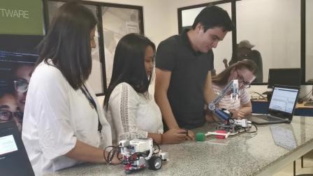 Estudiantes de la UDLA junto a un robot Lego