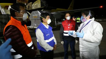 El alcalde de Quito, Jorge Yunda (azul) en el aeropuerto Mariscal Sucre de la capital, el 20 de abril de 2020, durante la llegada de 5.000 pruebas PCR.