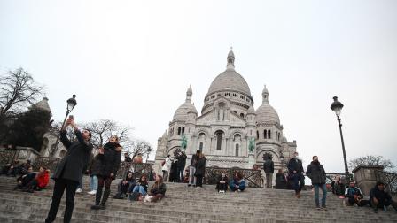 Personas afuera de una iglesia en París, luego de que el gobierno francés levantó el mandato de usar mascarilla en exteriores, el 2 de febrero de 2022.