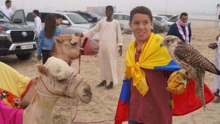 Un hincha ecuatoriano posa en el desierto de Qatar con un halcón y junto a un camello.