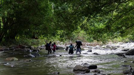 Varias personas cruzando uno de los tramos de la selva del Darién, entre Colombia y Panamá, septiembre de 2022. 